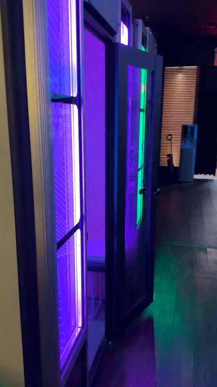 Walking past the private karaoke rooms, their doorways lit in purple and green.